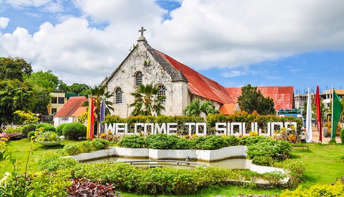 City of Siquijor Welcome Sign, behind which is the Spanish colonial era church Saint Francis de Assisi, Siquijor