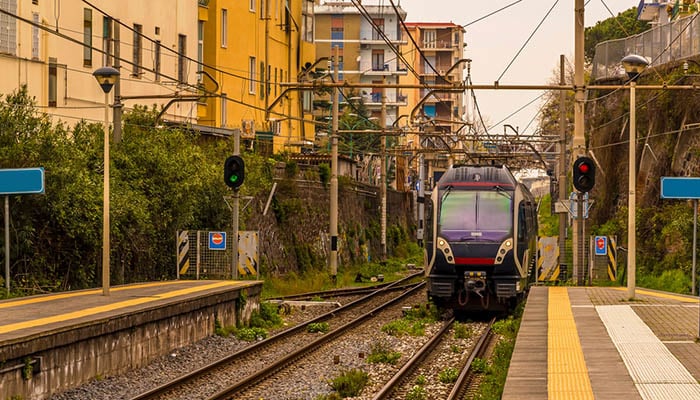 A view down a platform with a train approaching on the railway line between Naples and Sorrento, Italy