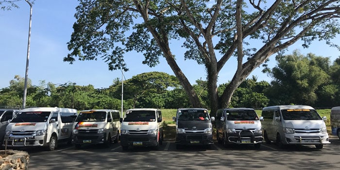 Minivans lined up outside of Puerto Princesa International Airport, waiting for tourists for transport to El Nido