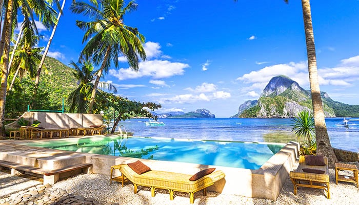 Tropical luxury holiday resort in El Nido. Infinity pool with Islands in the background on a sunny day.