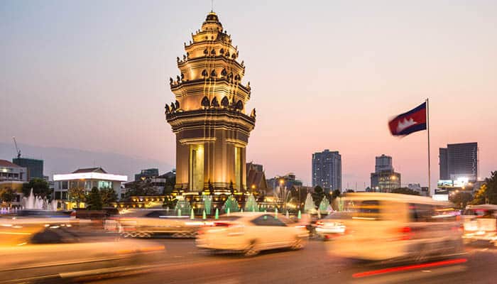 Traffic rushes around the Independence monument, with its Khmer architecture style, in Phnom Penh. Blurred motion with long exposure.