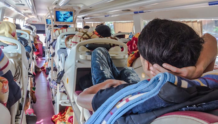 A man watching TV on a long-distance sleeper bus in Vietnam, daytime